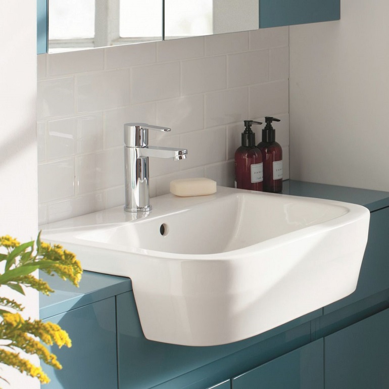 picture of a bathroom with blue cabins, white tiles and a semi recessed vanity basin