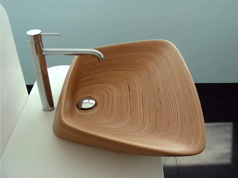 picture of bathroom with a wooden basin on a white cabinets, beside a stainless steel tab 