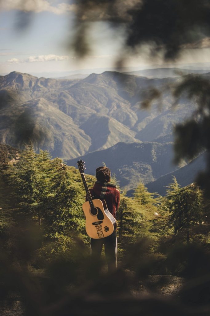 A person traveling with a guitar